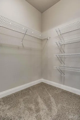 a view of an empty room and chandelier fan