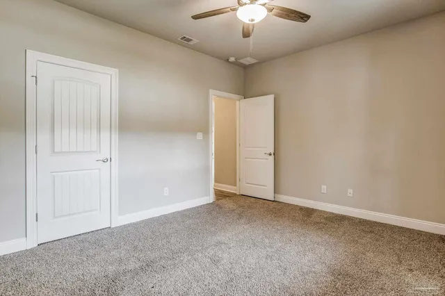 an empty room with chandelier fan