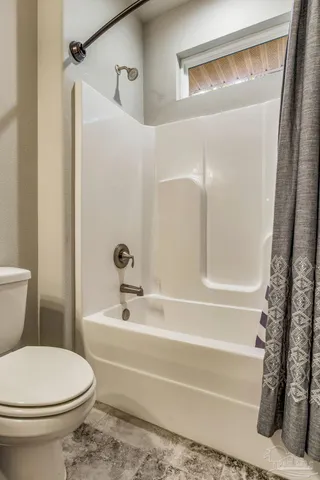 a view of an empty room with wooden floor and a ceiling fan
