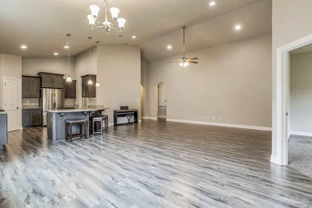 a kitchen with kitchen island granite countertop a wooden floor and chairs