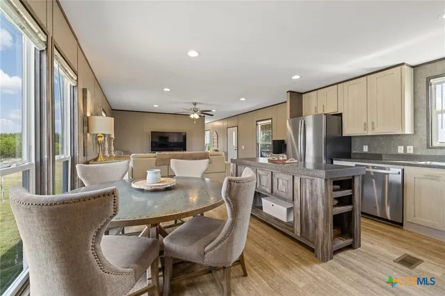 a kitchen with stainless steel appliances granite countertop a stove top oven a sink dishwasher and cabinets with wooden floor