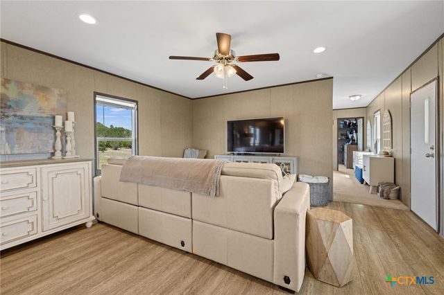 a spacious bedroom with a large bed and a chandelier fan