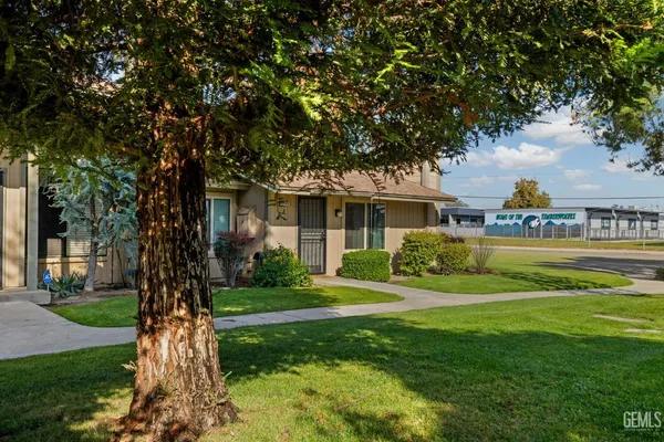 a front view of a house with a garden and trees
