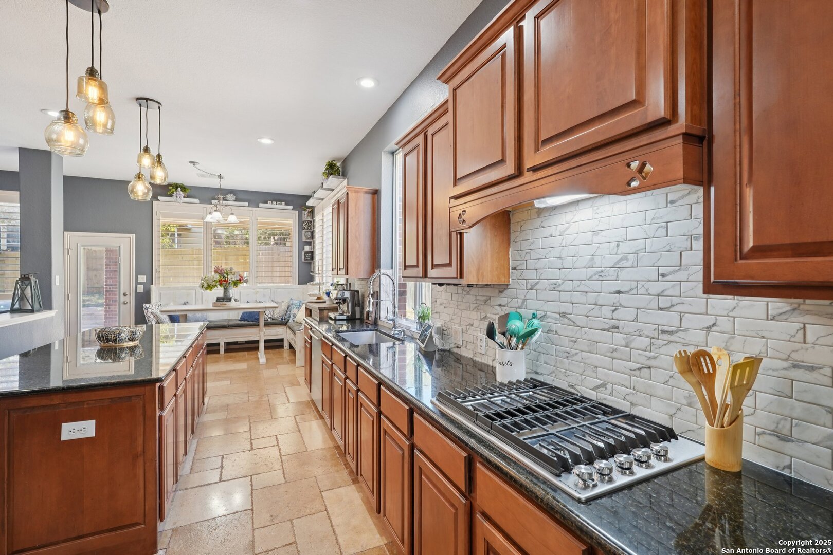 16107 Los Sedona Helotes, TX 78023 - Photo 14 of 59 a kitchen with stainless steel appliances granite countertop a stove a sink dishwasher a microwave oven and a dining table with wooden cabinet