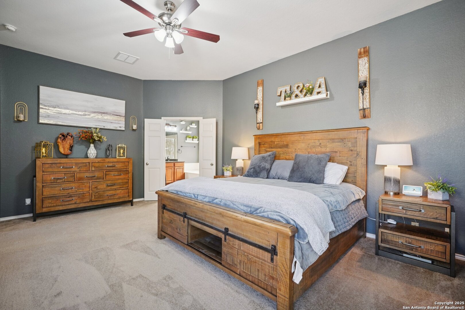 16107 Los Sedona Helotes, TX 78023 - Photo 24 of 59 a spacious bedroom with a bed and a chandelier