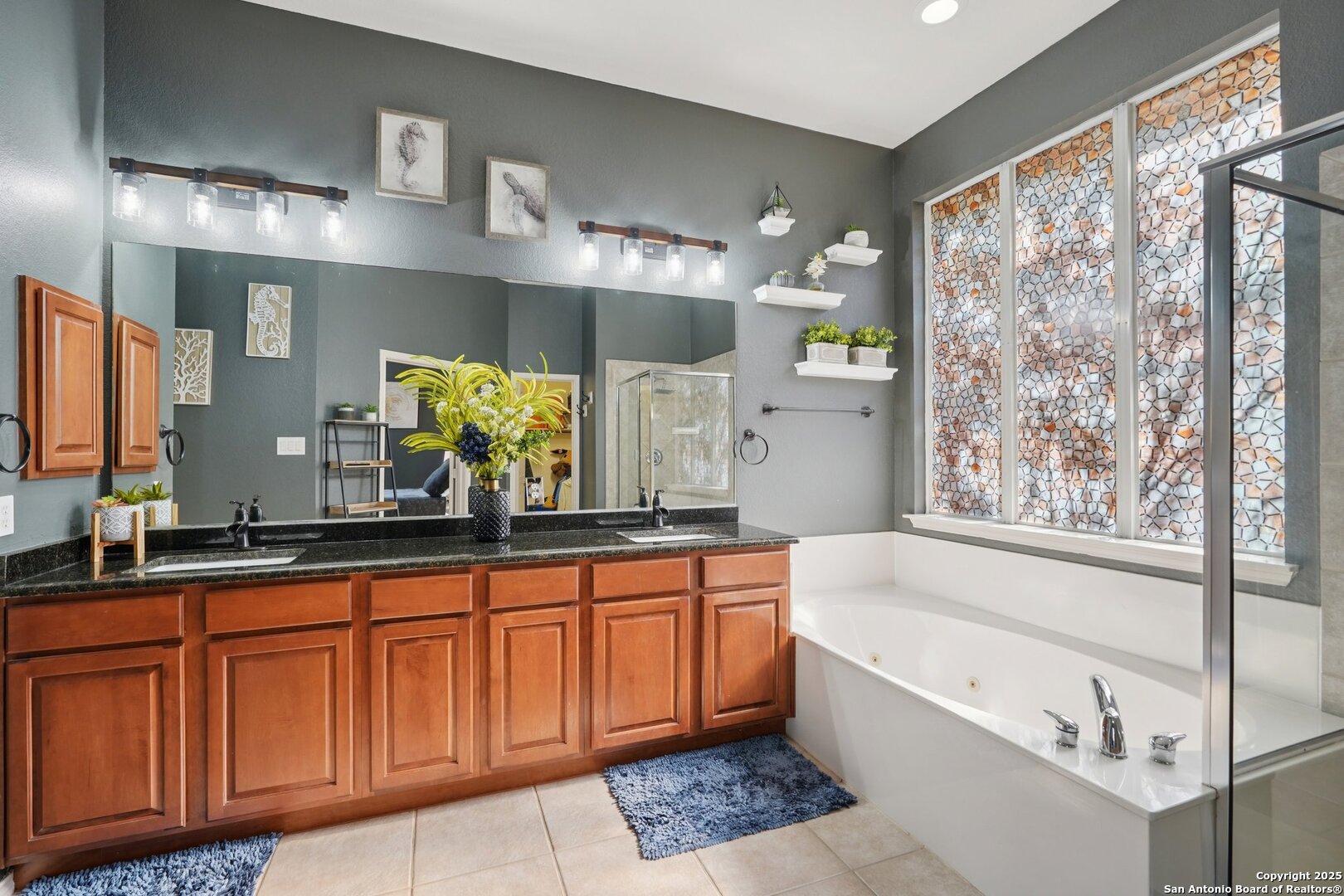 16107 Los Sedona Helotes, TX 78023 - Photo 26 of 59 a bathroom with a bathtub a double vanity sink and mirror