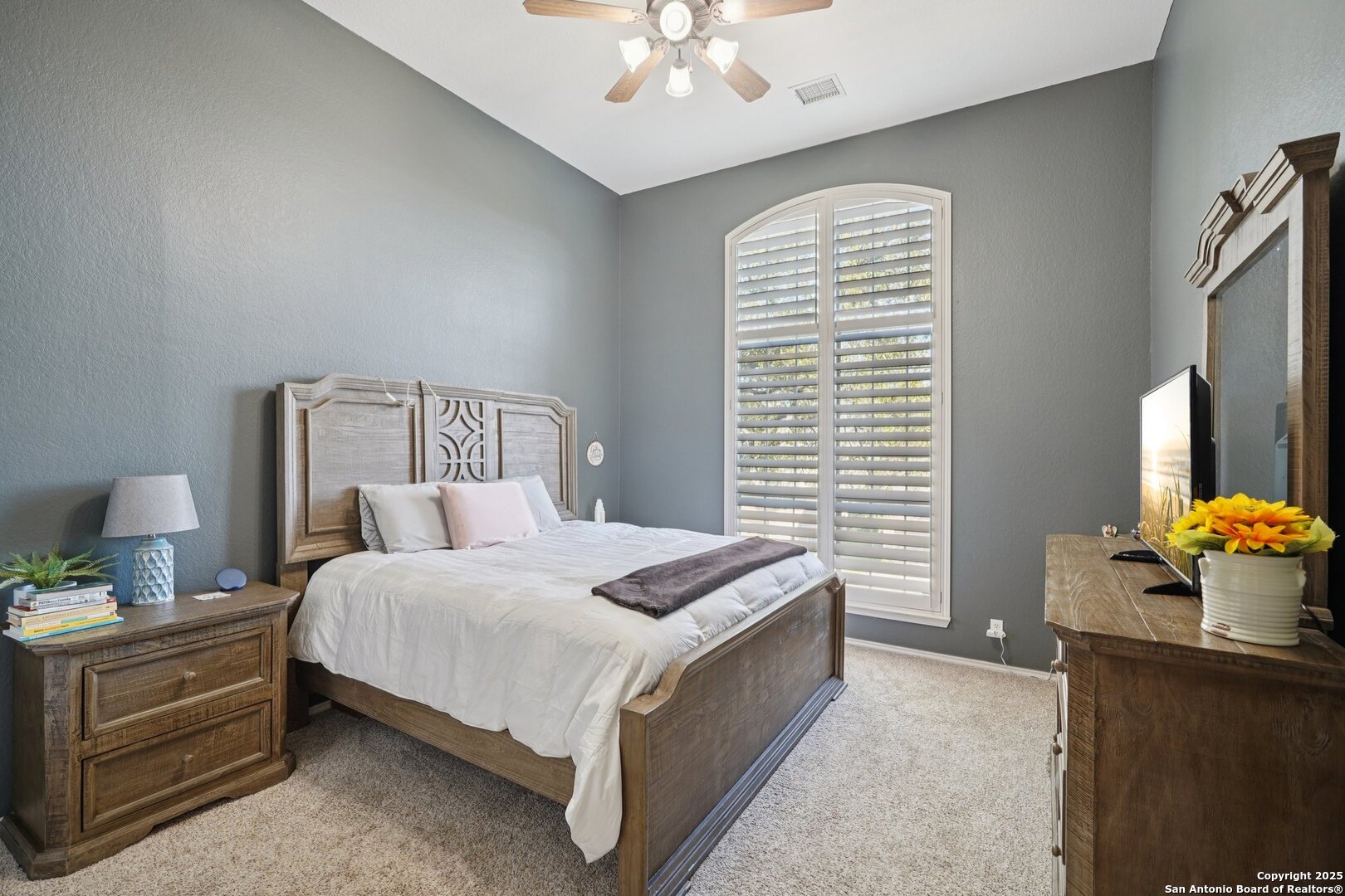 16107 Los Sedona Helotes, TX 78023 - Photo 33 of 59 a bedroom with a bed and a chandelier