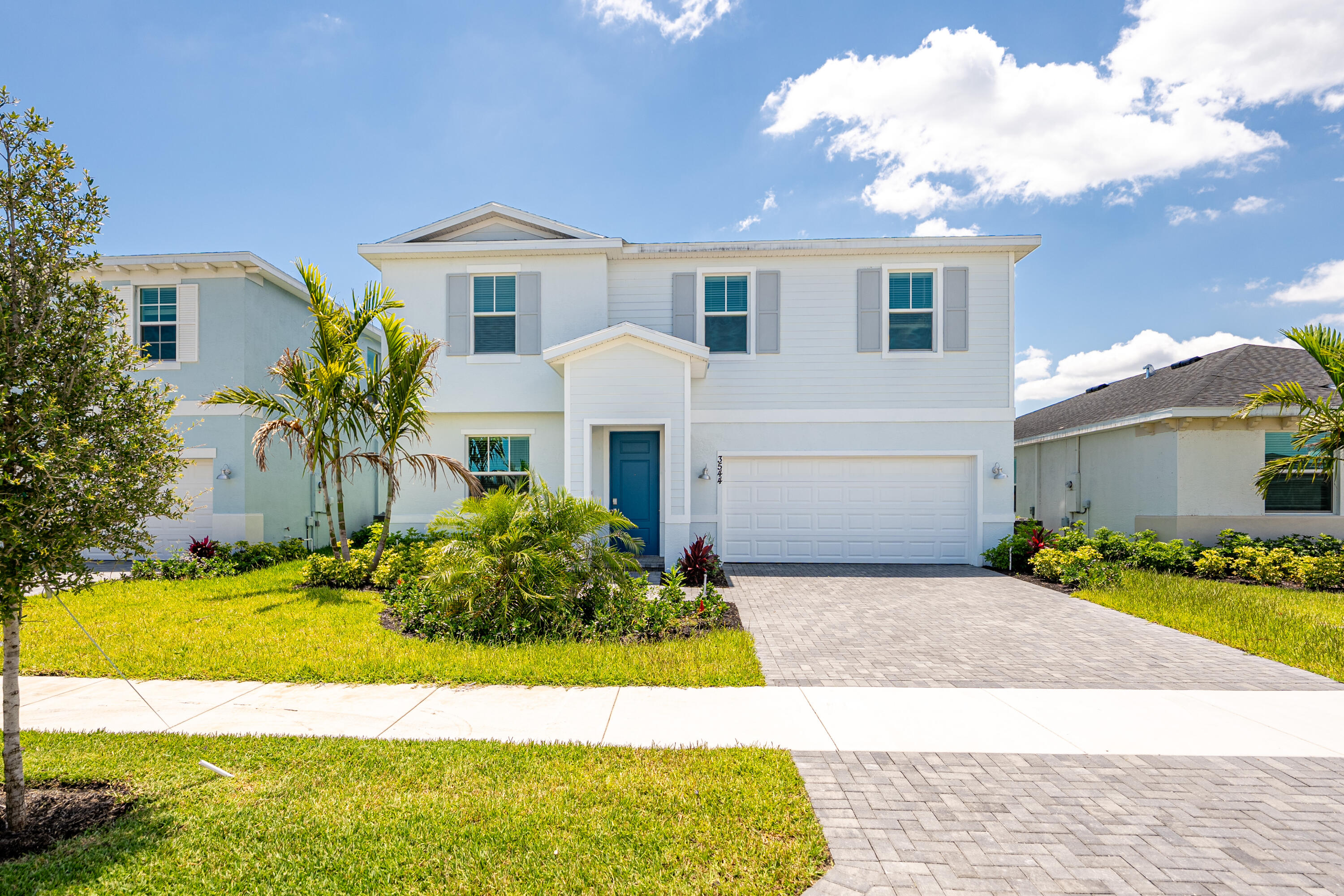 a front view of a house with a yard and garage