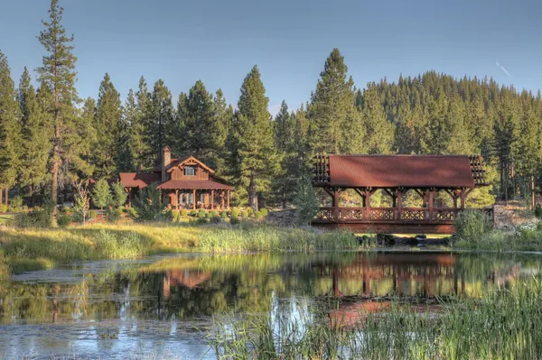 a view of a lake with a yard and large trees