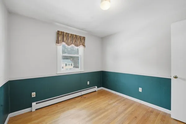 an empty room with window and wooden floor