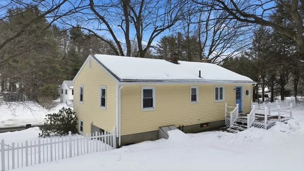 a view of a white house with a yard covered in snow