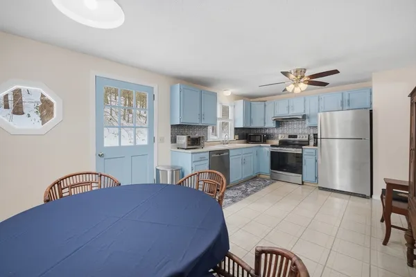 a kitchen with granite countertop a stove a sink dishwasher a refrigerator with cabinets and wooden floor