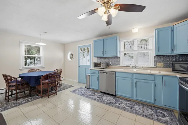 a kitchen with a dining table chairs and white cabinets
