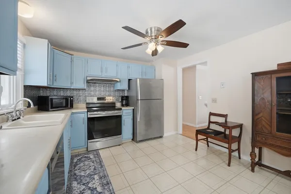 a kitchen with a refrigerator a sink and a stove top oven