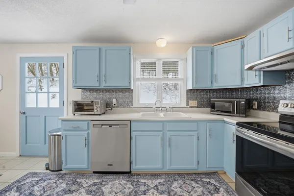 a kitchen with stainless steel appliances granite countertop a stove a sink and a microwave