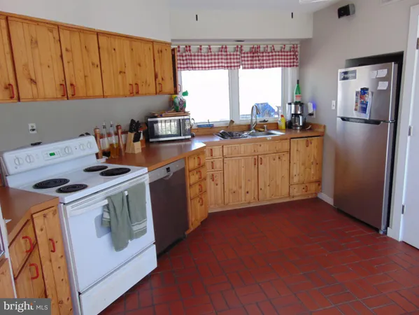 a kitchen with a stove a refrigerator and a sink