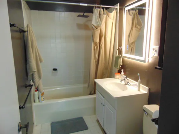 a bathroom with a sink vanity mirror and a bathtub