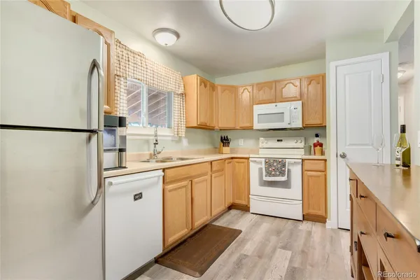 a kitchen with white cabinets and white appliances