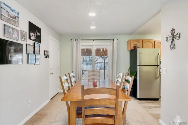 a view of a dining room with furniture a kitchen and chandelier