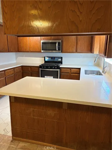 a kitchen with kitchen island a sink stainless steel appliances and cabinets