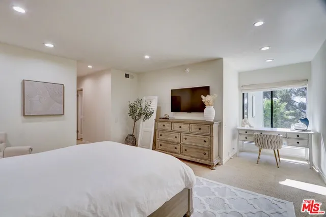 a bedroom with a bed and a flat screen tv in the kitchen