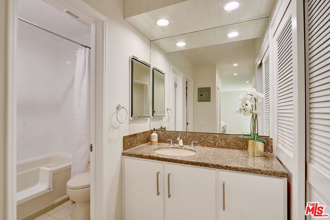 2345 Roscomare Road, Unit 303 Los Angeles, CA 90077 - Photo 14 of 23 a bathroom with a granite countertop sink and a mirror