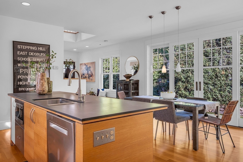 38 Downing Road Lexington, MA 02421 - Photo 11 of 41 a kitchen with stainless steel appliances granite countertop a sink table and chairs
