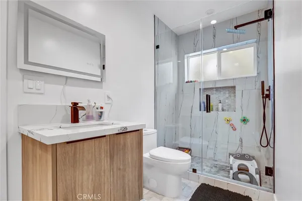 a bathroom with a sink a toilet and shower