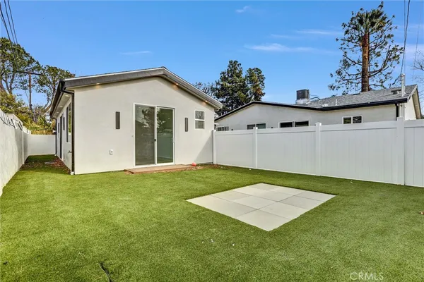 a view of kitchen with stainless steel appliances granite countertop a stove a sink and white cabinets