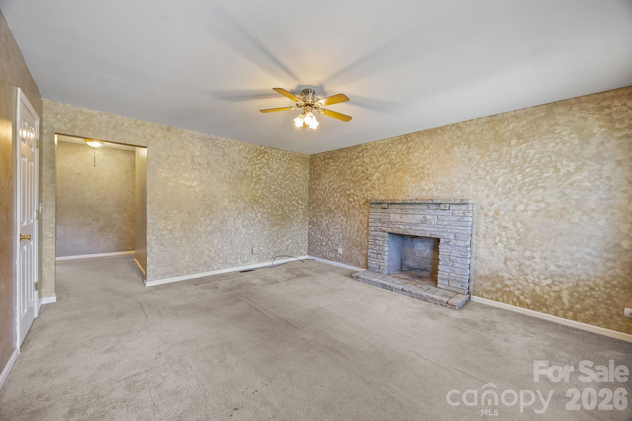 1311 Jenkins Road Gastonia, NC 28052 - Photo 14 of 47 a view of a room with a ceiling fan and a fireplace