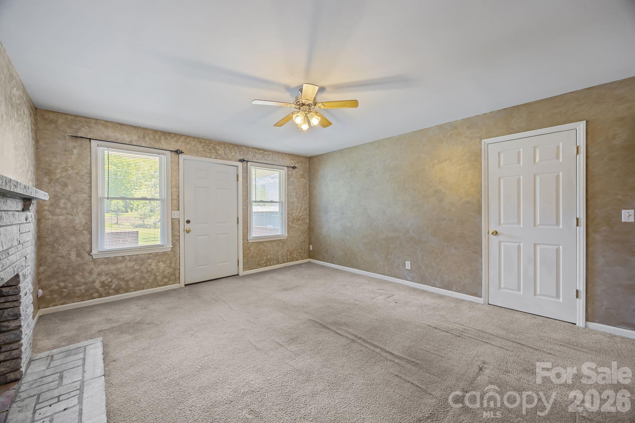 1311 Jenkins Road Gastonia, NC 28052 - Photo 16 of 47 an empty room with windows and chandelier fan