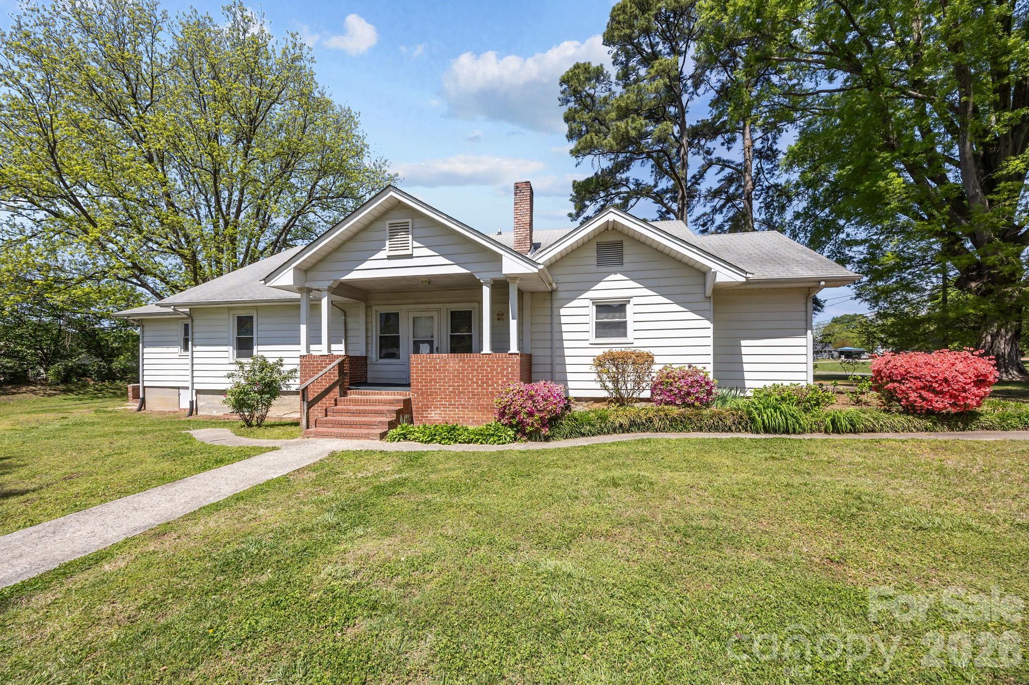 1311 Jenkins Road Gastonia, NC 28052 - Photo 42 of 47 a front view of a house with a garden and trees