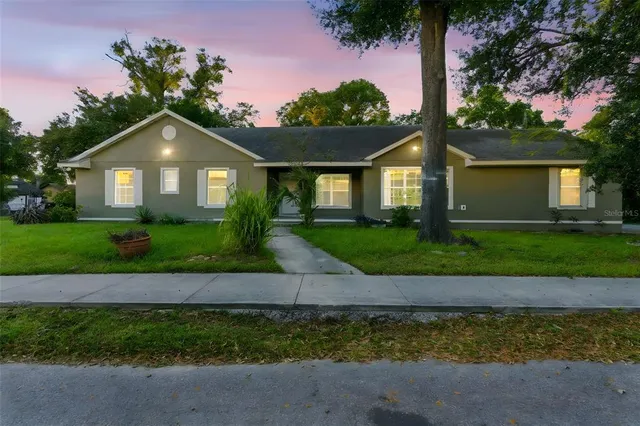 a front view of a house with a garden and yard