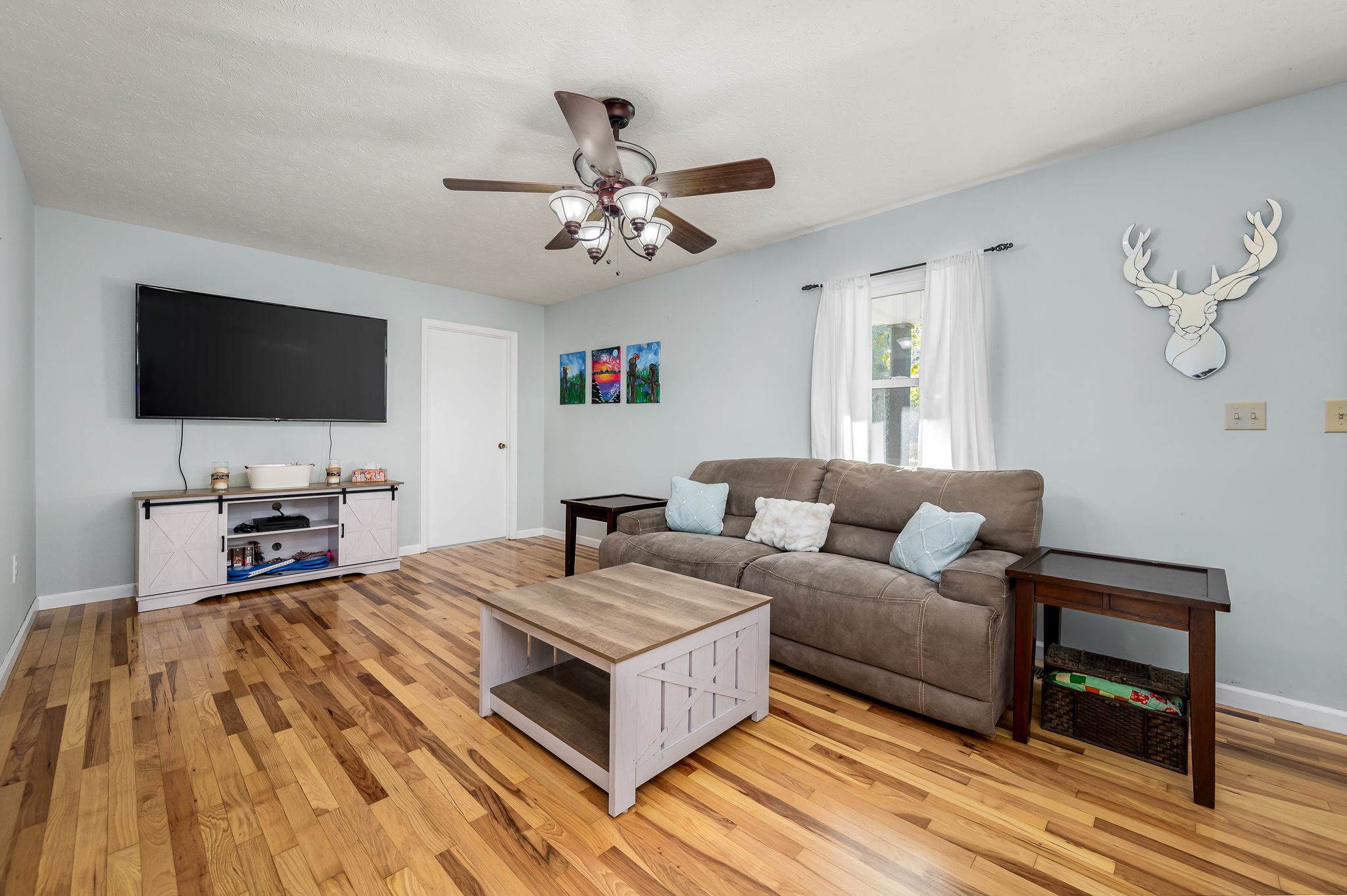 109 Higgins Road Woodbury, TN 37190 - Photo 10 of 49 Refinished hardwood floors, neutral paint, ceiling fan and a window overlooking the front yard. The utility room is off of this area.