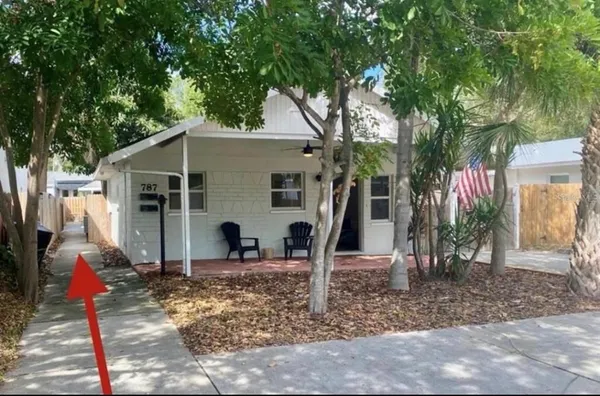 a view of a house with backyard and trees