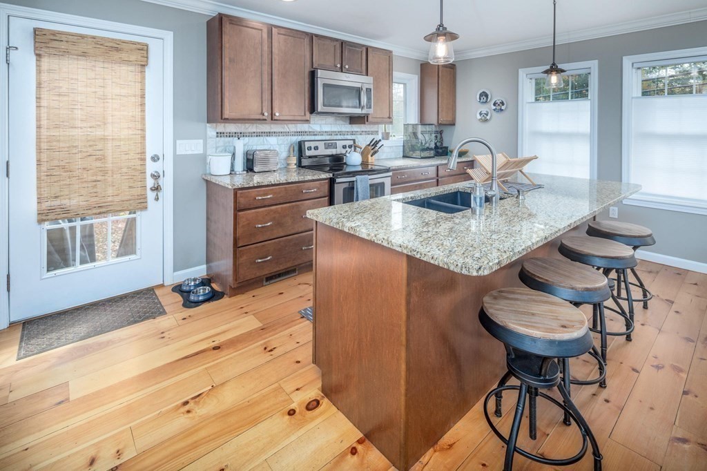 8 Collette Road Sturbridge, MA 01518 - Photo 6 of 28 a kitchen with kitchen island granite countertop a table chairs stove and cabinets