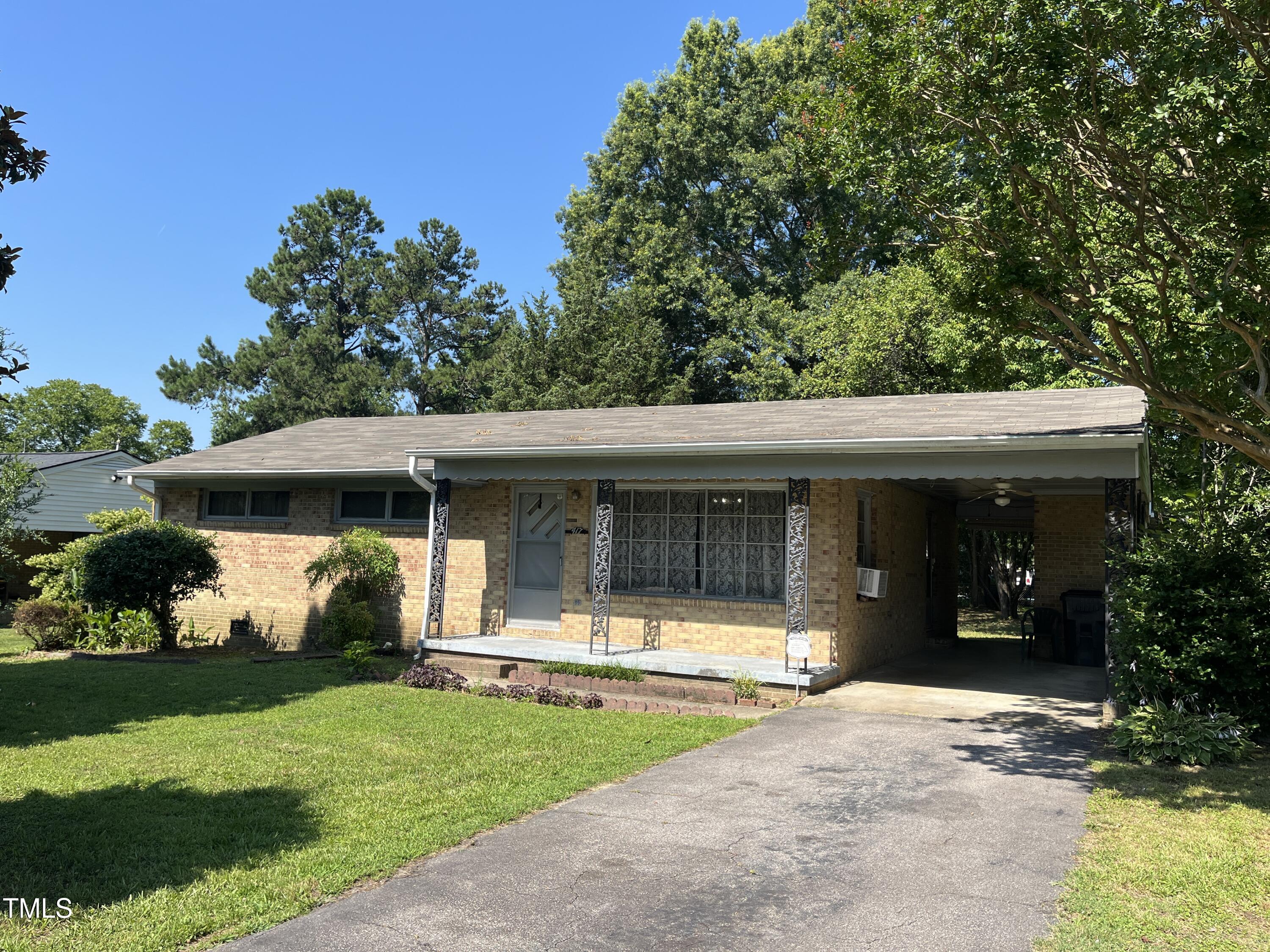 a front view of a house with a yard and potted plants