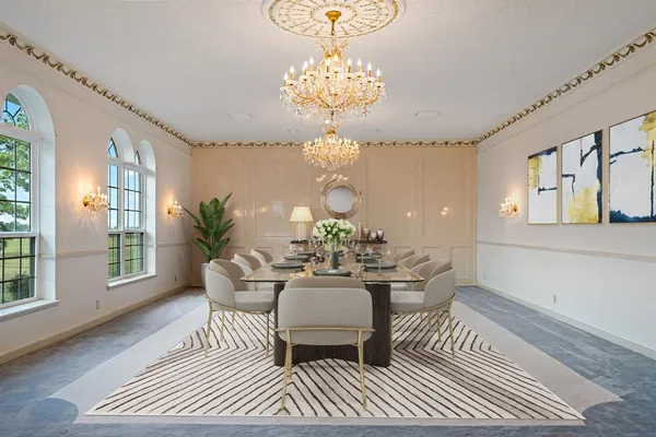 a dining room with wooden floor a chandelier a rug and a chandelier