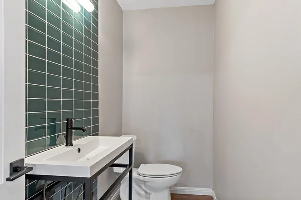 a bathroom with a sink a toilet and mirror