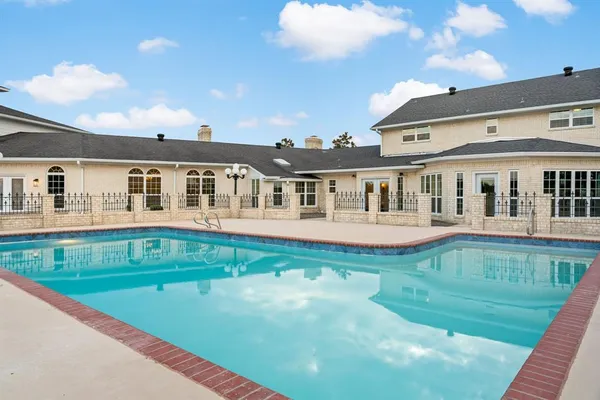a view of house with a big yard and potted plants