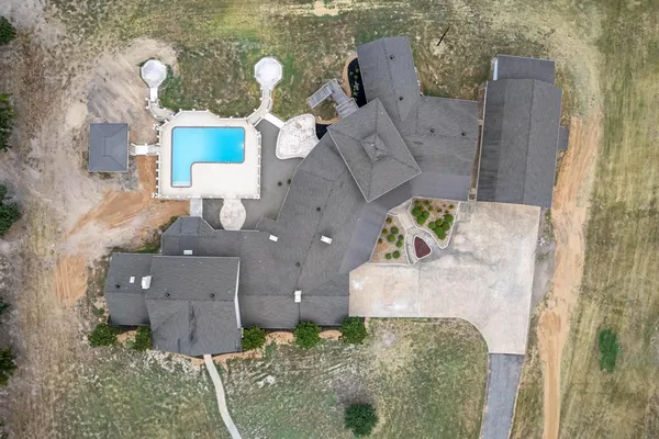 an aerial view of a house with a yard and a large tree