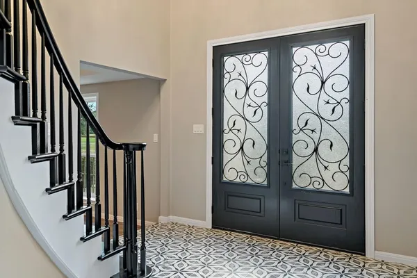 a view of a hallway with wooden door and stairs