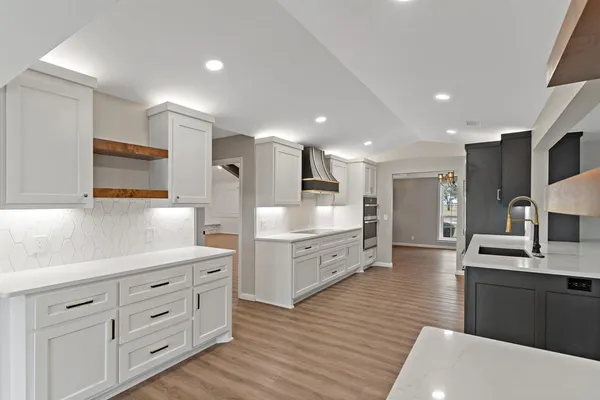 a large kitchen with stainless steel appliances lots of counter space and wooden floor