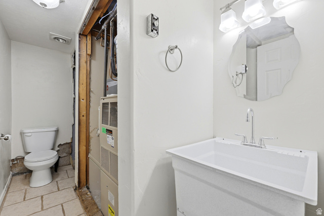 1486 3rd Street Ogden, UT 84404 - Photo 18 of 26 Utility sink with a chrome faucet, illuminated by a three-bulb vanity light fixture