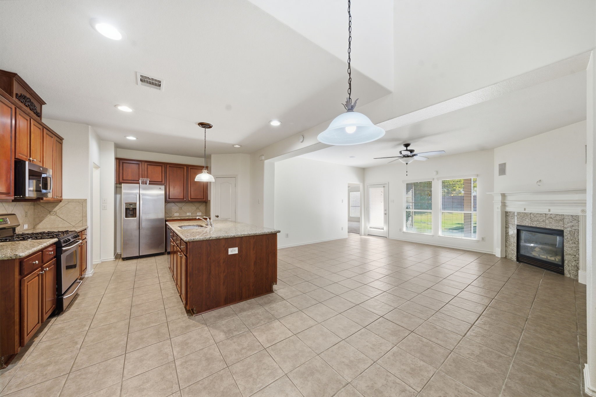 23139 Tranquil Spring Lane Katy, TX 77494 - Photo 9 of 22 a large kitchen with kitchen island a large counter space a sink stainless steel appliances and cabinets
