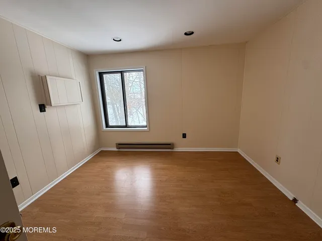 an empty room with window and mirror