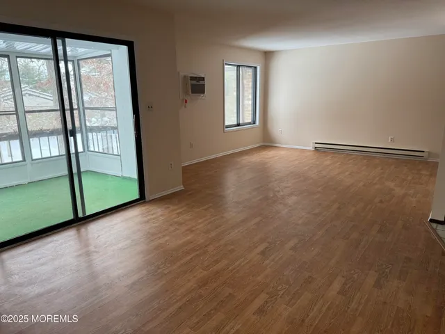 a view of a room with wooden floor and windows