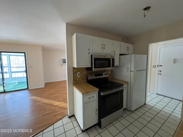 a kitchen with granite countertop a refrigerator and a stove top oven