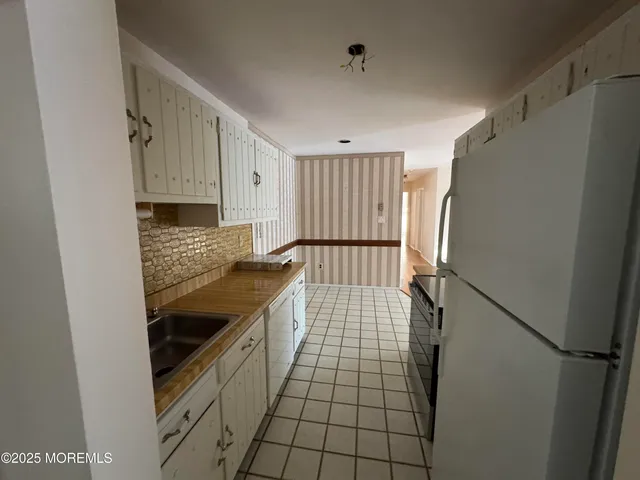 a kitchen with a refrigerator and a sink