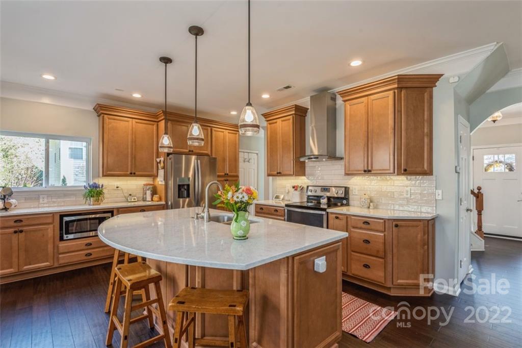 739 West Cheval Drive Fort Mill, SC 29708 - Photo 16 of 36 a kitchen with a stove a sink a center island wooden floor and living room